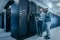 De foto toont twee ingenieurs in een modern datacenter, werkend met hun computer.